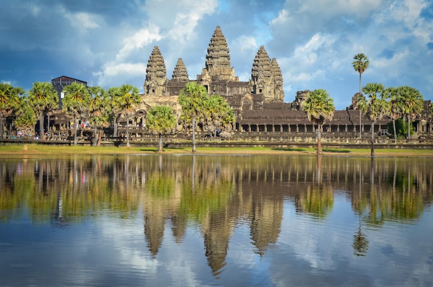 Angkor Wat temple complex reflected in the pond under a blue sky in Cambodia