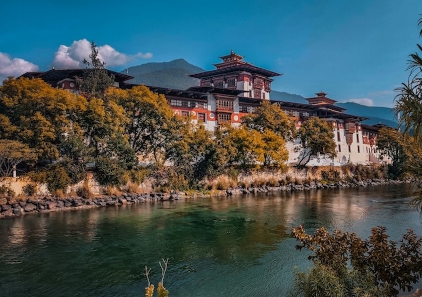 Punakha Dzong in Bhutan beside a river with mountains in the background