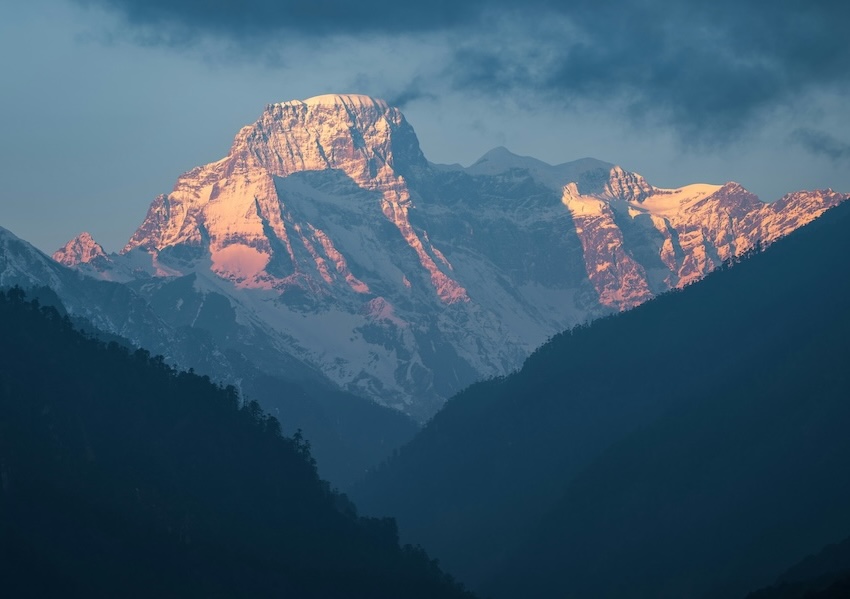 Snow covered Himalayan mountain peak illuminated by sunlight in Bhutan