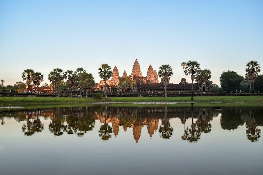 Angkor Wat temple complex reflected in a peaceful pond at sunset in Cambodia