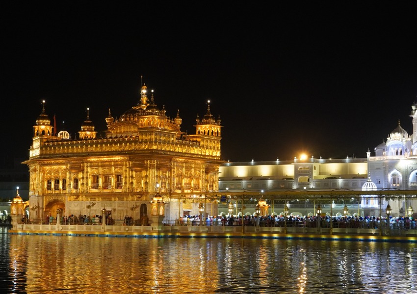 Golden Temple illuminated at night, reflecting beautifully in the sacred water in Amritsar, India.